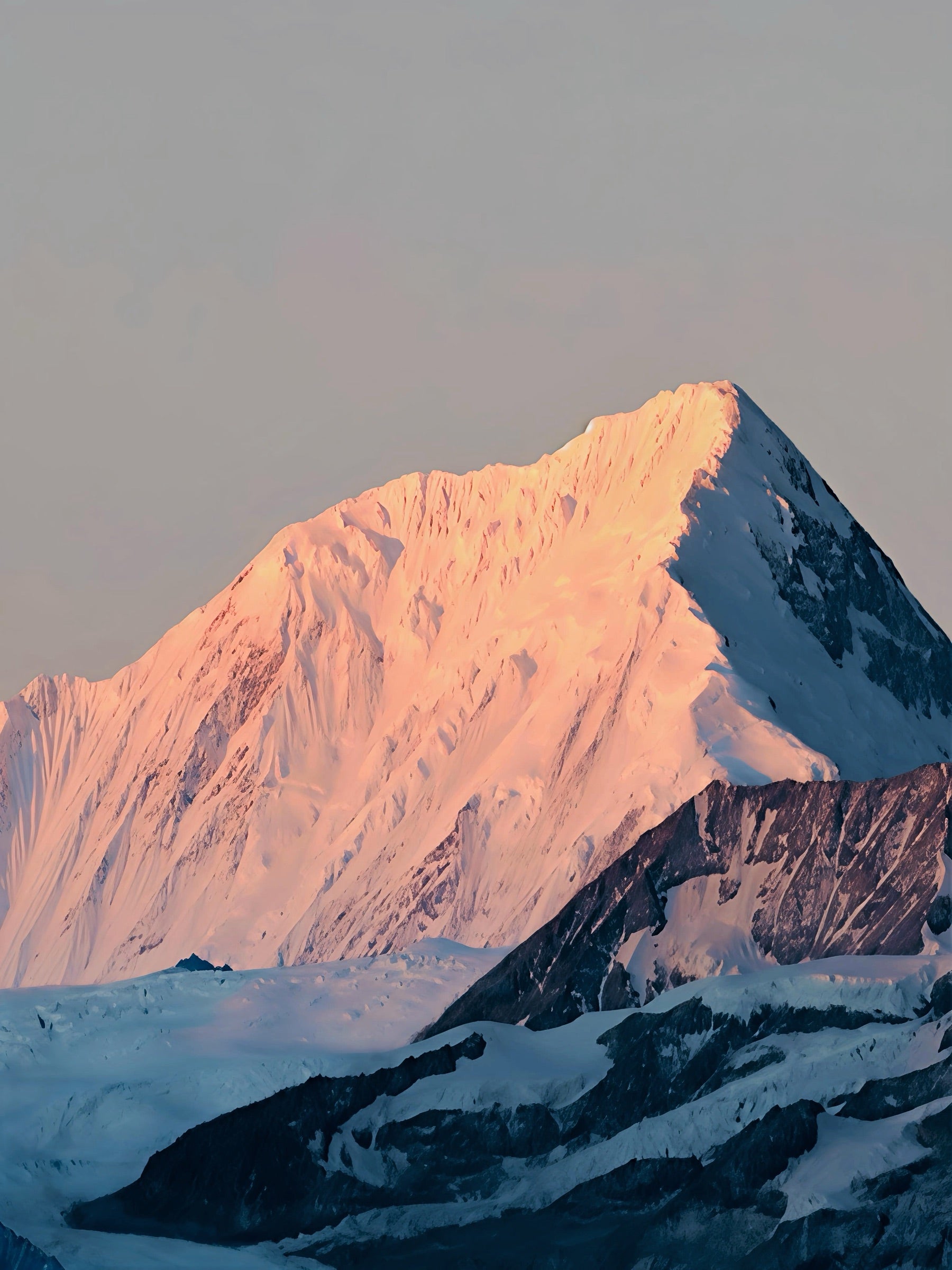 A snow-covered mountain peak glowing at sunrise